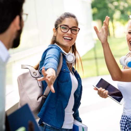 A group of international students taking a selfie together at a famous landmark, dressed casually and smiling.