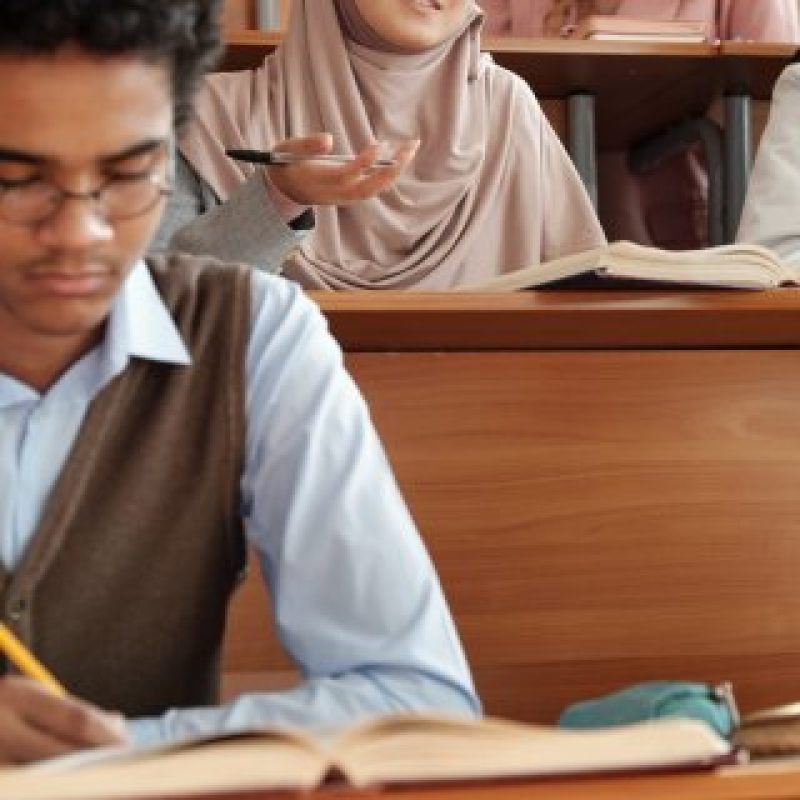 Happy international students in an English class, expressing excitement and collaboration while studying the language